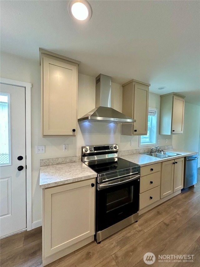 40 E Skywater Pl, Shelton, WA 98584 - kitchen featuring appliances with stainless steel finishes, wall chimney range hood, light wood-style floors, and light countertops