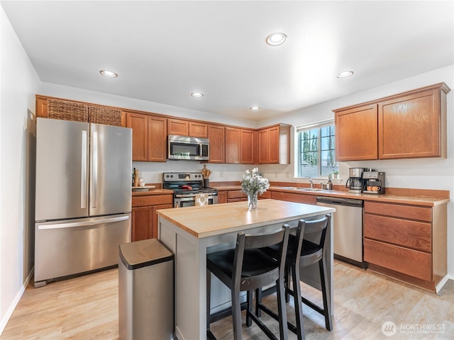 2135 Roper Ln, Wenatchee, WA 98801 - kitchen featuring stainless steel appliances, recessed lighting, light wood-style flooring, brown cabinets, and a breakfast bar