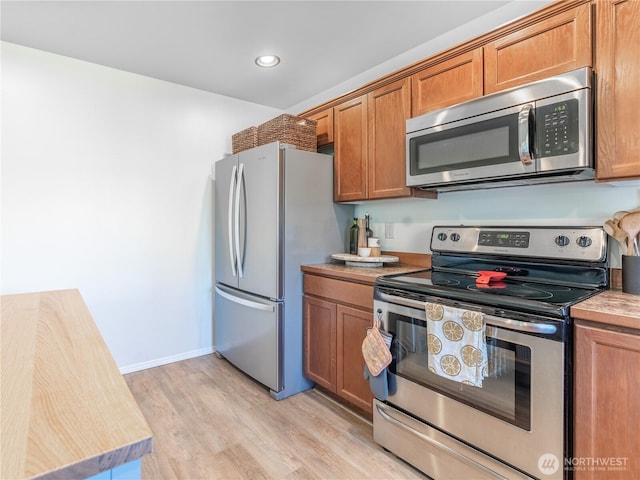 2135 Roper Ln, Wenatchee, WA 98801 - kitchen featuring stainless steel appliances, light wood finished floors, brown cabinets, light countertops, and recessed lighting