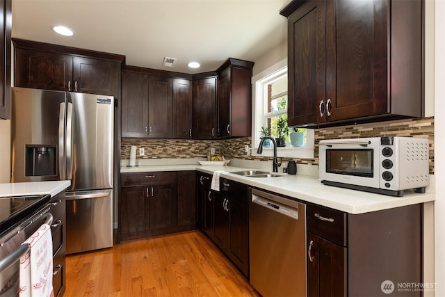 7923 220th St SW, Edmonds, WA 98026 - kitchen featuring appliances with stainless steel finishes, light countertops, dark brown cabinetry, decorative backsplash, and recessed lighting