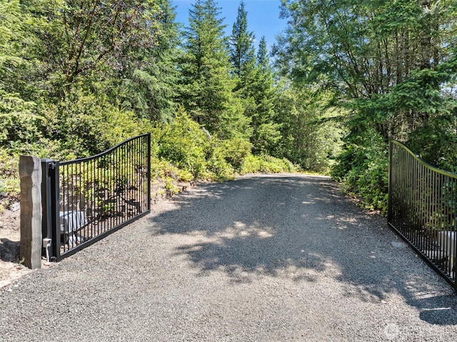 931 SW Moose Hill Ct, Port Orchard, WA 98367 - view of dirt / gravel road featuring a gate, a gated entry, and a forest view