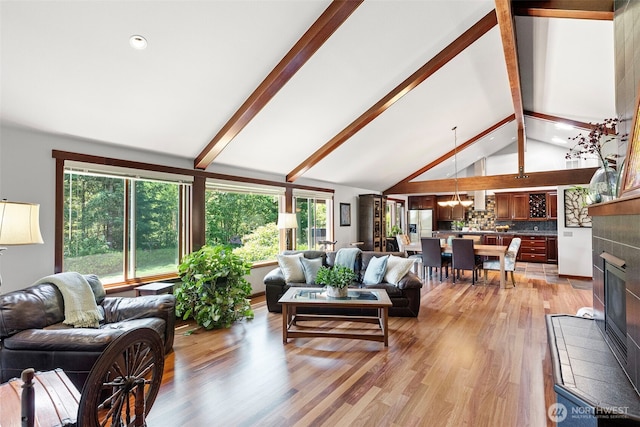 931 SW Moose Hill Ct, Port Orchard, WA 98367 - living area with beamed ceiling, plenty of natural light, light wood finished floors, a tiled fireplace, and a chandelier