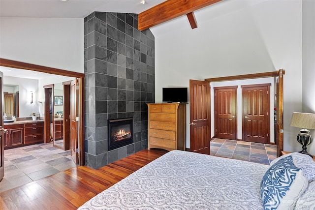931 SW Moose Hill Ct, Port Orchard, WA 98367 - bedroom featuring high vaulted ceiling, a fireplace, beam ceiling, and wood finished floors