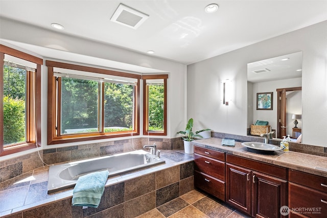 931 SW Moose Hill Ct, Port Orchard, WA 98367 - bathroom featuring healthy amount of natural light, vanity, a garden tub, recessed lighting, and stone finish floors
