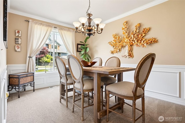 8206 66th Avenue Ct E, Puyallup, WA 98371 - dining room featuring carpet floors, a chandelier, ornamental molding, a decorative wall, and a wainscoted wall