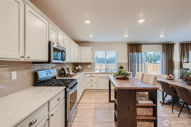 1212 15th Ave, Sultan, WA 98294 - kitchen featuring appliances with stainless steel finishes, light countertops, tasteful backsplash, recessed lighting, and white cabinets