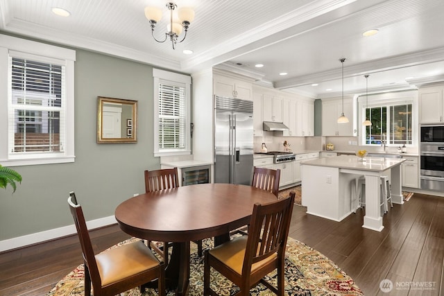 3913 W Briarcliff Ln, Seattle, WA 98199 - dining space with healthy amount of natural light, dark wood-type flooring, recessed lighting, wine cooler, and crown molding
