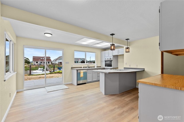 4126 Matia Dr, Ferndale, WA 98248 - kitchen with black appliances, light wood-style flooring, decorative light fixtures, and a textured ceiling