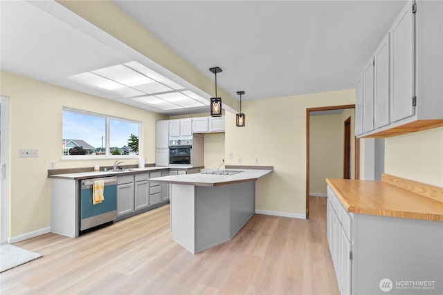 4126 Matia Dr, Ferndale, WA 98248 - kitchen with dishwasher, oven, a peninsula, light wood finished floors, and pendant lighting