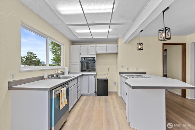 4126 Matia Dr, Ferndale, WA 98248 - kitchen featuring black appliances, a peninsula, light wood-style floors, and pendant lighting
