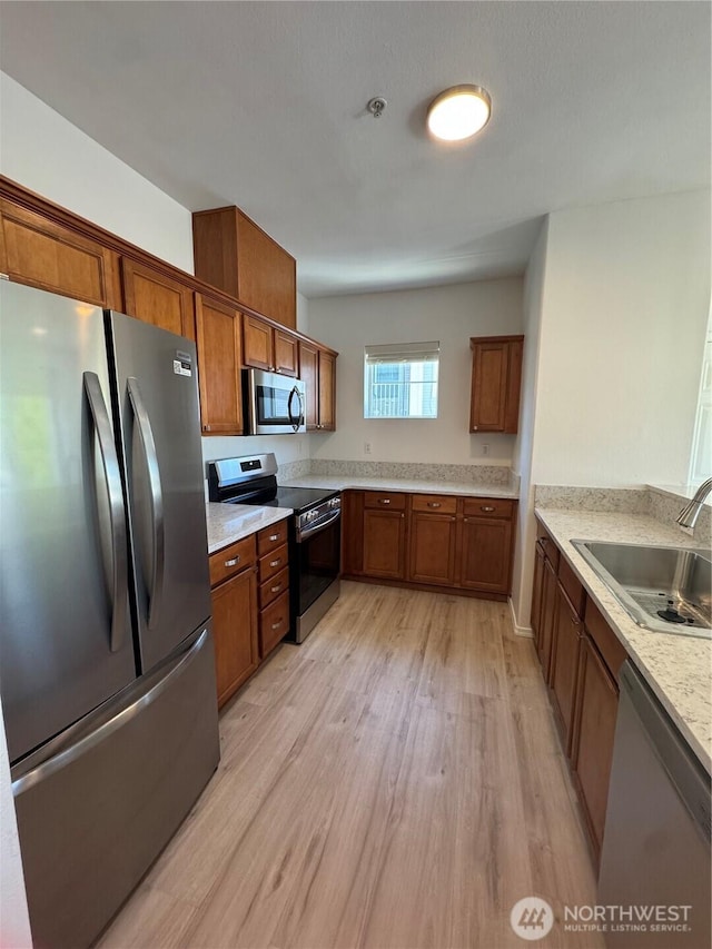 14915 38th Dr SE Unit Ii2051, Bothell, WA 98012 - kitchen featuring appliances with stainless steel finishes, brown cabinetry, and light wood-style flooring