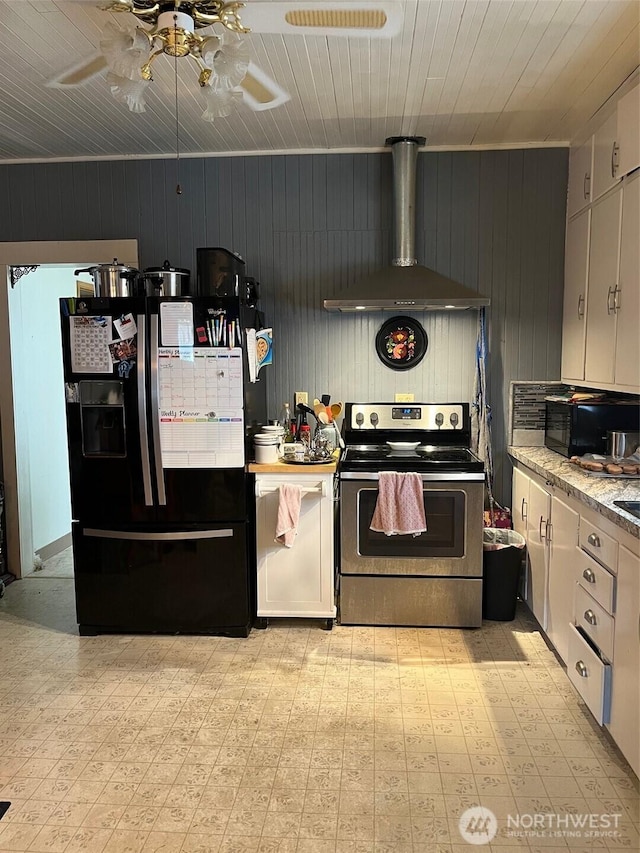 1205 49th St, Seaview, WA 98644 - kitchen featuring black appliances, wall chimney range hood, wooden walls, ceiling fan, and light flooring