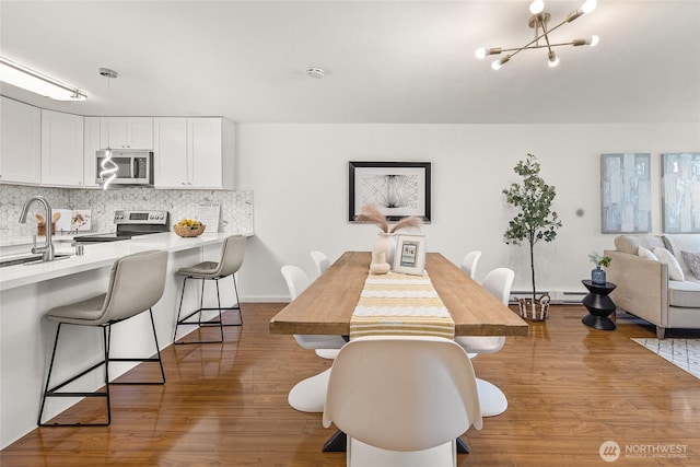 6347 137th Ave NE Unit 262, Redmond, WA 98052 - dining room featuring wood finished floors, a chandelier, and baseboard heating