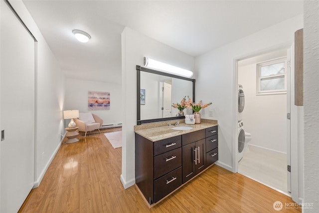 6347 137th Ave NE Unit 262, Redmond, WA 98052 - bathroom with stacked washer / dryer, vanity, wood finished floors, and baseboard heating
