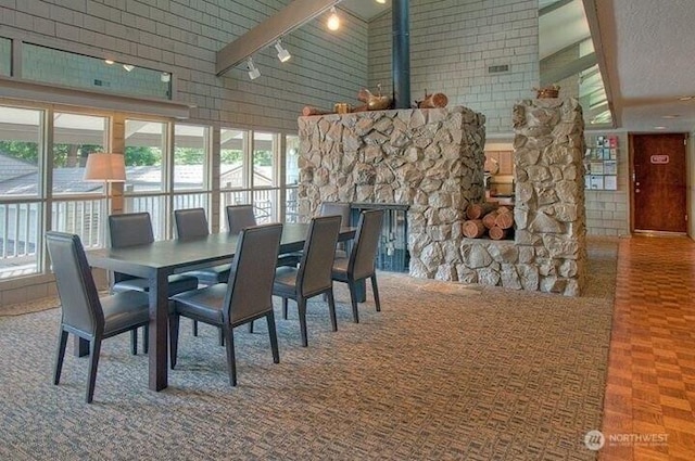 6347 137th Ave NE Unit 262, Redmond, WA 98052 - dining space with a high ceiling, rail lighting, and a stone fireplace