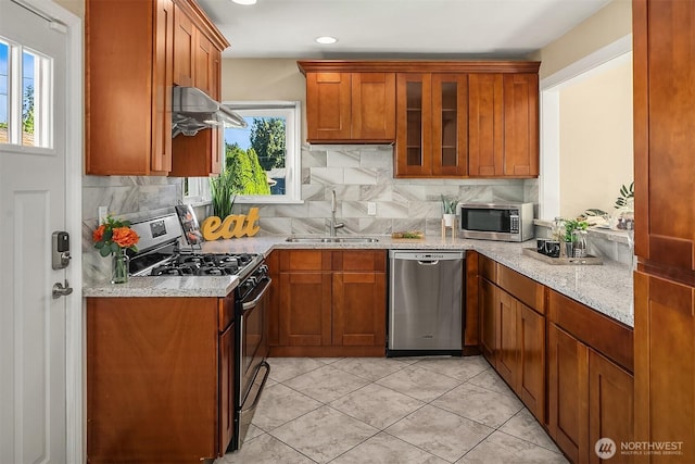 13316 30th Ave NE, Seattle, WA 98125 - kitchen featuring appliances with stainless steel finishes, ventilation hood, tasteful backsplash, light stone counters, and glass insert cabinets