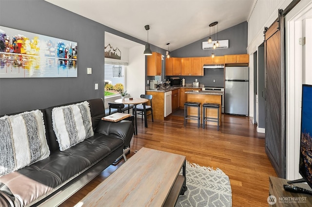 13316 30th Ave NE, Seattle, WA 98125 - living room featuring a barn door, vaulted ceiling, and dark wood-type flooring