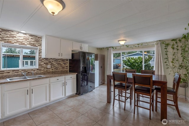31108 3rd Ave Unit 330, Black Diamond, WA 98010 - kitchen with black refrigerator with ice dispenser, decorative backsplash, white cabinets, and dark countertops