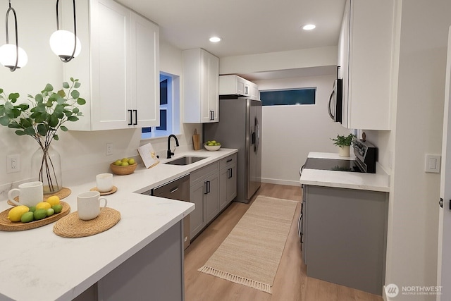 744 N 88th St, Seattle, WA 98103 - kitchen featuring stainless steel appliances, light wood-style flooring, white cabinetry, gray cabinets, and hanging light fixtures