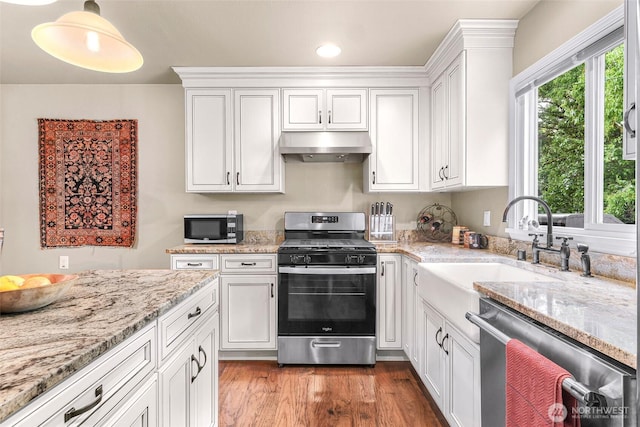 105 Shuksan St, Everson, WA 98247 - kitchen featuring appliances with stainless steel finishes, under cabinet range hood, white cabinets, light stone counters, and recessed lighting