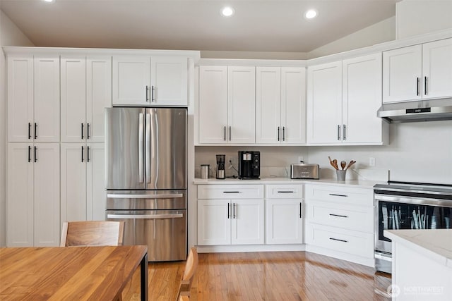 1738 Lilypad Pl E, Port Orchard, WA 98366 - kitchen with stainless steel appliances, under cabinet range hood, light countertops, white cabinets, and recessed lighting