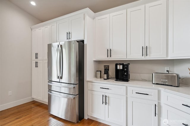 1738 Lilypad Pl E, Port Orchard, WA 98366 - kitchen featuring freestanding refrigerator, white cabinetry, light wood-style flooring, recessed lighting, and light stone countertops