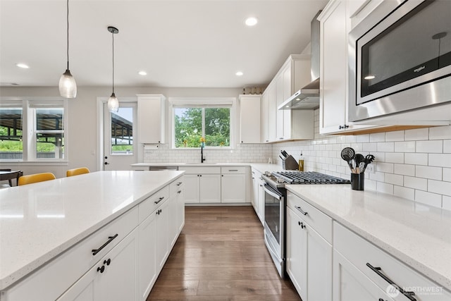 14717 73rd St E, Sumner, WA 98390 - kitchen featuring appliances with stainless steel finishes, wood finished floors, white cabinetry, decorative light fixtures, and recessed lighting
