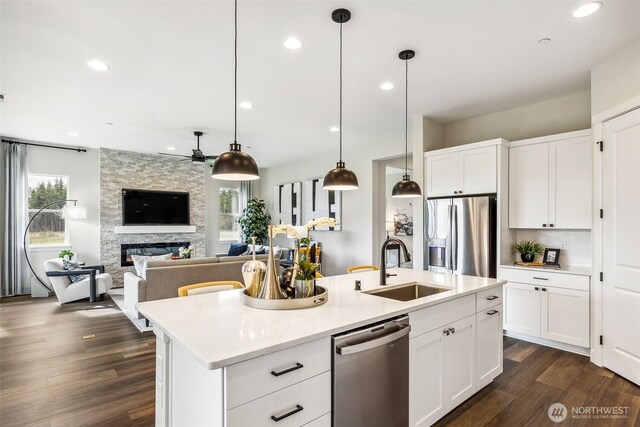 10527 134th Ave NE Unit 103, Lake Stevens, WA 98258 - kitchen featuring stainless steel appliances, a ceiling fan, a fireplace, dark wood-style flooring, and open floor plan