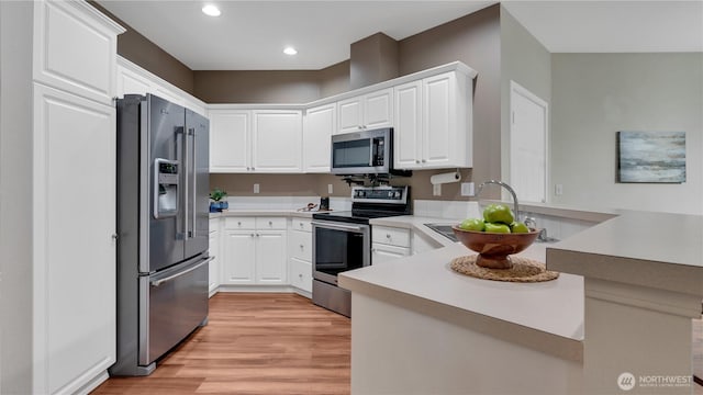 2104 Palisade Blvd Unit B-7, Dupont, WA 98327 - kitchen with appliances with stainless steel finishes, a peninsula, light wood finished floors, light countertops, and recessed lighting