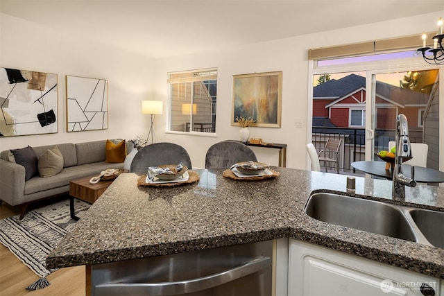 2840 139th Ave SE Unit 16, Bellevue, WA 98005 - kitchen with light wood-style floors, stainless steel dishwasher, dark stone counters, white cabinetry, and open floor plan