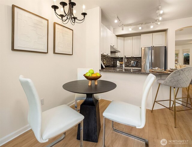 2840 139th Ave SE Unit 16, Bellevue, WA 98005 - dining room featuring light wood-style floors, a chandelier, arched walkways, and track lighting