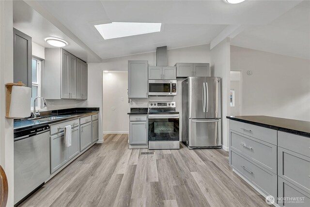 22111 108th Ave SE Unit 5, Kent, WA 98031 - kitchen featuring appliances with stainless steel finishes, gray cabinets, a skylight, light wood-style flooring, and lofted ceiling