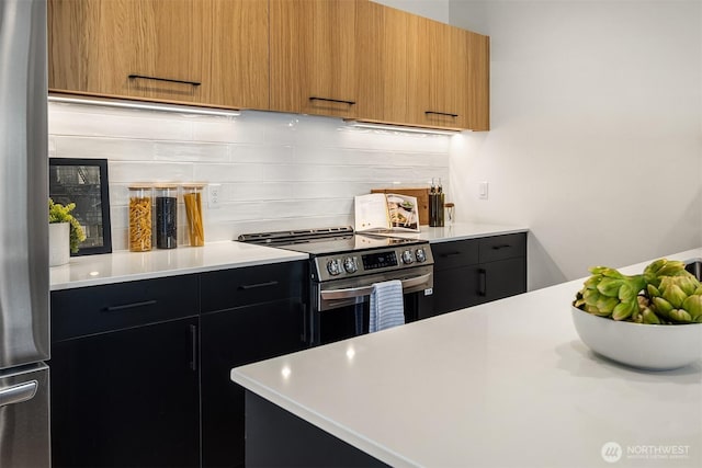 2419 NW 57th Unit B, Seattle, WA 98107 - kitchen featuring appliances with stainless steel finishes, light countertops, backsplash, modern cabinets, and dark cabinets