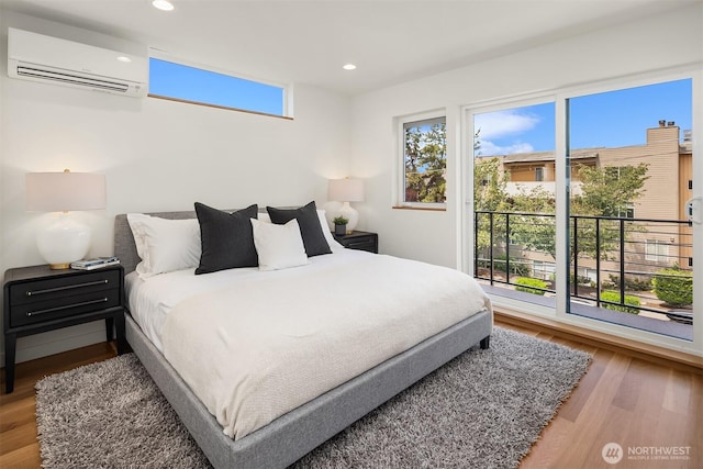 2419 NW 57th Unit B, Seattle, WA 98107 - bedroom featuring an AC wall unit, wood finished floors, and recessed lighting