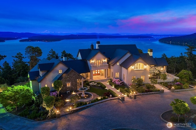 678 Primrose Ln, Friday Harbor, WA 98250 - french country home with a balcony, a chimney, a water view, and stucco siding