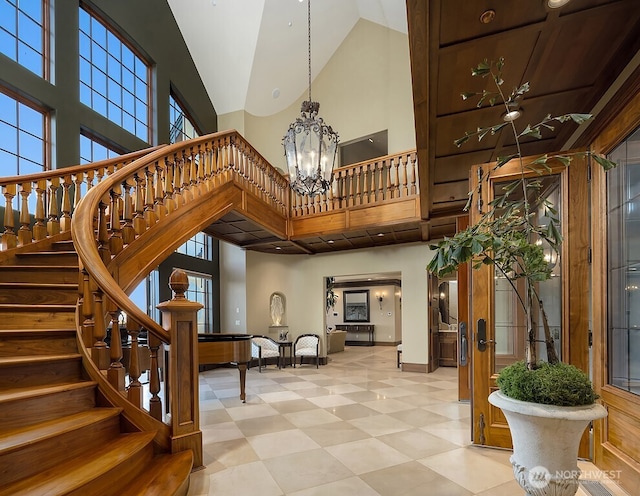 678 Primrose Ln, Friday Harbor, WA 98250 - stairs featuring high vaulted ceiling, a chandelier, tile patterned floors, and plenty of natural light