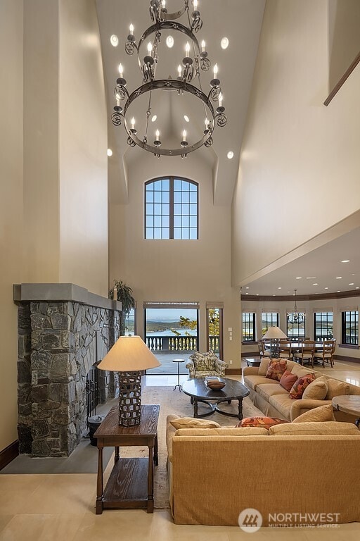 678 Primrose Ln, Friday Harbor, WA 98250 - living area with a high ceiling, a chandelier, a stone fireplace, and recessed lighting