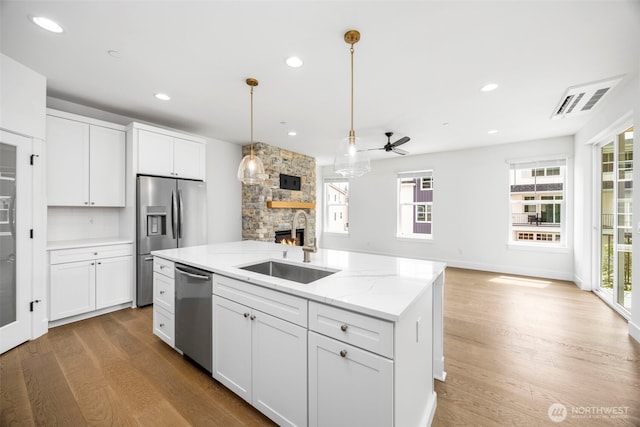 9 160th St SE, Bothell, WA 98012 - kitchen with stainless steel appliances, a fireplace, wood finished floors, ceiling fan, and open floor plan