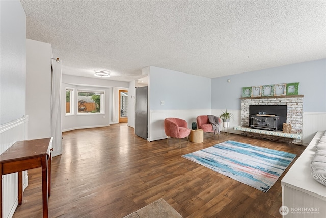 15627 SE 263rd Pl, Covington, WA 98042 - living area with wood finished floors, a textured ceiling, wainscoting, and a fireplace