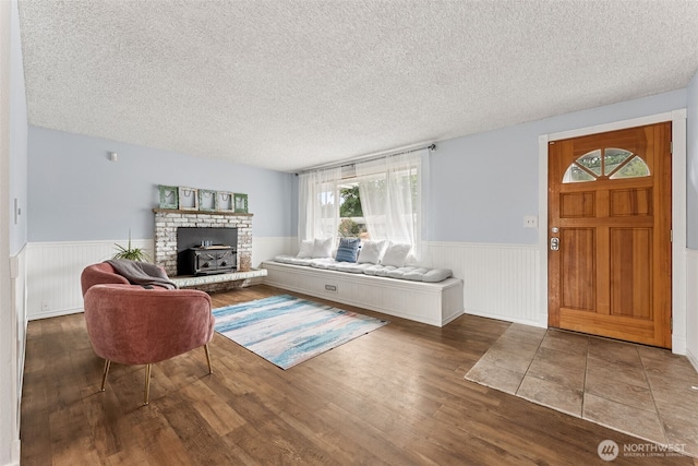 15627 SE 263rd Pl, Covington, WA 98042 - living area featuring a wainscoted wall, a textured ceiling, wood finished floors, and a brick fireplace