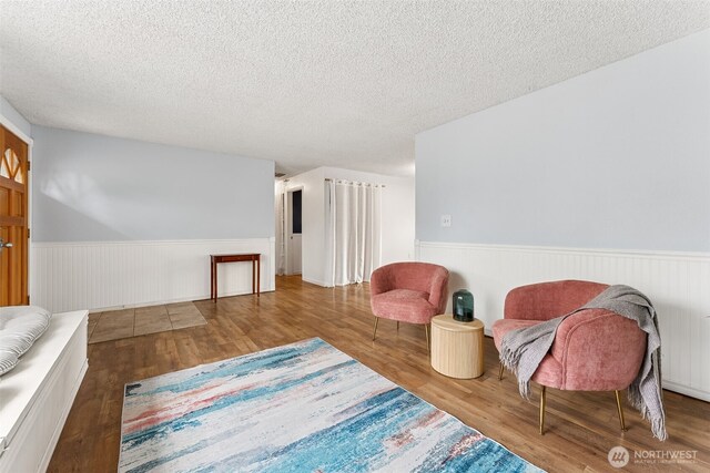15627 SE 263rd Pl, Covington, WA 98042 - living area featuring wainscoting, wood finished floors, and a textured ceiling