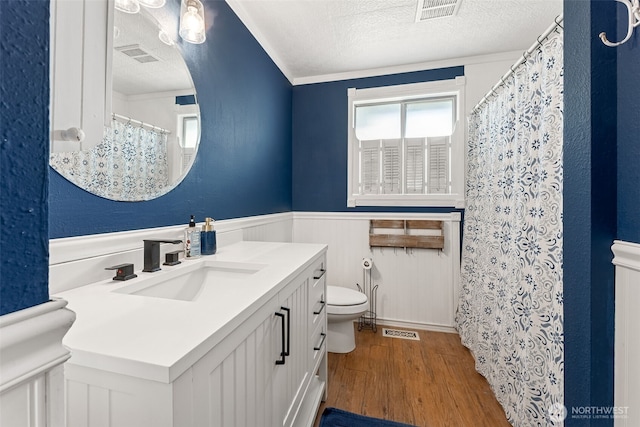 15627 SE 263rd Pl, Covington, WA 98042 - bathroom featuring wood finished floors, a textured ceiling, vanity, a wainscoted wall, and curtained shower