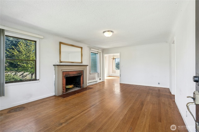 2000 31st Ave S, Seattle, WA 98144 - unfurnished living room with a baseboard heating unit, healthy amount of natural light, a textured ceiling, wood finished floors, and a fireplace