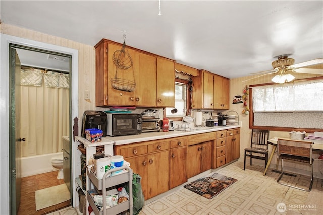 1109 S 61st St, Tacoma, WA 98408 - kitchen with light countertops, a ceiling fan, brown cabinets, and light floors