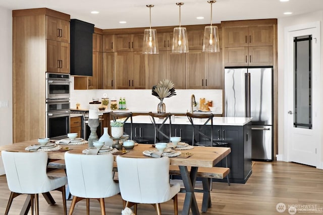 5412 Lonicera Dr, Blaine, WA 98230 - kitchen featuring appliances with stainless steel finishes, wood finished floors, recessed lighting, light countertops, and pendant lighting