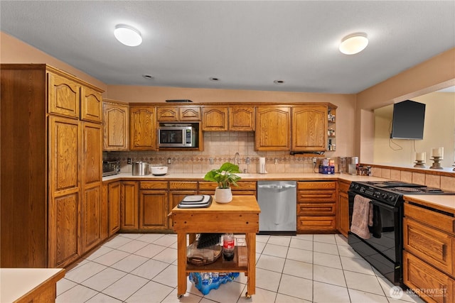 1714 N Astor Ct, East Wenatchee, WA 98802 - kitchen featuring stainless steel appliances, brown cabinets, light countertops, tasteful backsplash, and open shelves