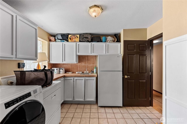 1714 N Astor Ct, East Wenatchee, WA 98802 - kitchen with freestanding refrigerator, light countertops, light tile patterned floors, white cabinets, and tasteful backsplash