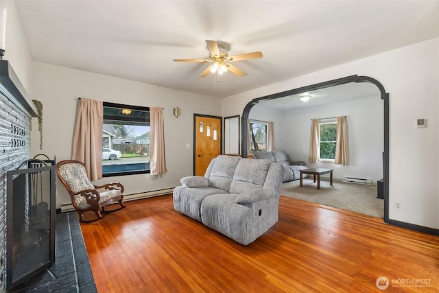 111 Aurora St, Centralia, WA 98531 - living area featuring baseboard heating, ceiling fan, a fireplace, and wood finished floors