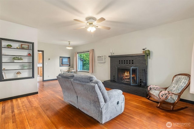 111 Aurora St, Centralia, WA 98531 - living area featuring a fireplace, wood finished floors, a wall mounted AC, and a ceiling fan