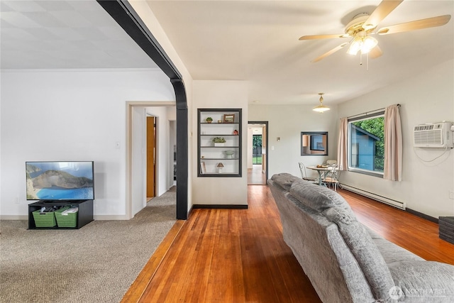 111 Aurora St, Centralia, WA 98531 - living room featuring a baseboard heating unit, a ceiling fan, a wall mounted air conditioner, and arched walkways